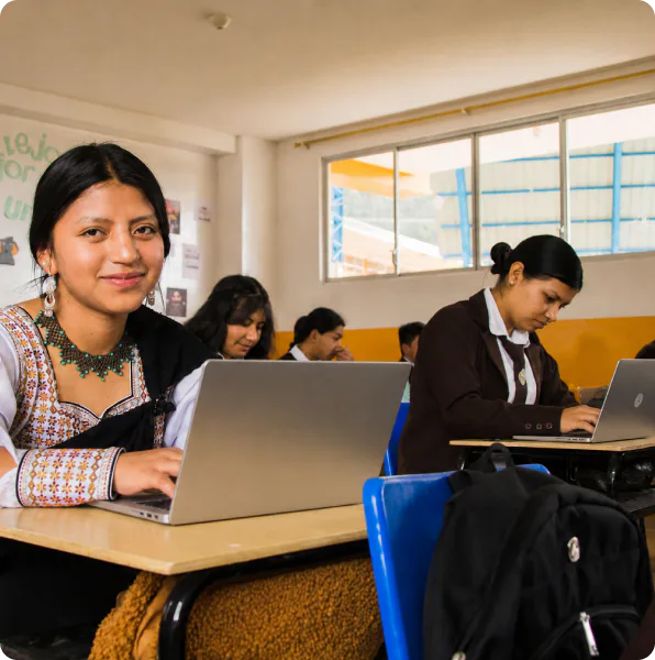 Teacher helping students use laptops